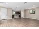 Open-concept living area showcasing wood-look tile floors and seamless flow into kitchen and dining at 15587 S 180Th Ln, Goodyear, AZ 85338