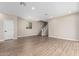 Spacious living room featuring wood-look tile floors, staircase access, and neutral wall paint at 15587 S 180Th Ln, Goodyear, AZ 85338