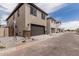 Two story homes lined in a row, with two car garages and minimal landscaping in the front yards at 15587 S 180Th Ln, Goodyear, AZ 85338