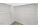 A spacious walk-in closet offering ample storage space with its installed racks and carpeting at 17561 W Pierson St, Goodyear, AZ 85395