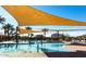 Resort-style community pool with palm trees, lounge chairs, and sunshades at 196 W Yellow Wood Ave, San Tan Valley, AZ 85140