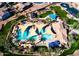 Aerial view of a community pool with sunshades, palm trees, and lounge chairs at 196 W Yellow Wood Ave, San Tan Valley, AZ 85140