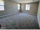 Carpeted bedroom with natural light from three windows creating a bright and airy atmosphere at 2945 S 232Nd Dr, Buckeye, AZ 85326