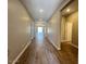 Long hallway featuring wood-look flooring and neutral walls, leading to various rooms at 2945 S 232Nd Dr, Buckeye, AZ 85326