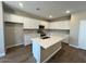Bright kitchen with white cabinets, a central island, and stainless steel appliances at 2945 S 232Nd Dr, Buckeye, AZ 85326