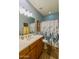 Well-lit bathroom with wood cabinetry, neutral countertops, and a shower/tub combo, offering a functional space at 41814 N Crooked Stick Rd, Anthem, AZ 85086