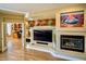 Living room featuring a fireplace, built-in shelving and adjacent office space at 41814 N Crooked Stick Rd, Anthem, AZ 85086