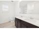 Bright bathroom featuring a double vanity with dark wood cabinets, white countertops, and a large mirror at 4348 W Hannah St, San Tan Valley, AZ 85144