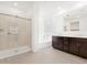 Modern bathroom showcasing a glass-enclosed shower, soaking tub, and a double vanity with dark wood cabinetry at 4348 W Hannah St, San Tan Valley, AZ 85144