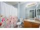 Bright bathroom featuring a vanity with sink and a toilet with a floral shower curtain at 11501 W Charter Oak Rd, El Mirage, AZ 85335