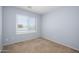Bright, carpeted bedroom with natural light provided by a single window at 11501 W Charter Oak Rd, El Mirage, AZ 85335
