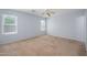 Spacious carpeted bedroom with natural light from dual windows and ceiling fan at 11501 W Charter Oak Rd, El Mirage, AZ 85335