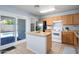 Functional kitchen with an island, stainless steel refrigerator, ample cabinetry, and access to the backyard pool area at 11501 W Charter Oak Rd, El Mirage, AZ 85335