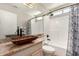 Bathroom featuring a vessel sink, granite countertop, and a tub with white tiling at 1631 E Carla Vista Dr, Chandler, AZ 85225