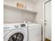 Bright laundry room featuring a newer white front load washer and dryer and a storage shelf at 1631 E Carla Vista Dr, Chandler, AZ 85225