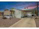 Charming home exterior with a covered porch, carport, and desert landscaping at 201 S Greenfield Rd # 51, Mesa, AZ 85206