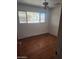 Modest bedroom with a ceiling fan, window, and wood flooring at 3820 W Encanto Blvd, Phoenix, AZ 85009