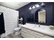 Modern bathroom with vanity, bright lighting, dark blue paint, elegant mirror, white shower curtain and decorative shelves at 4529 E Thistle Landing Dr, Phoenix, AZ 85044