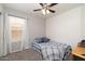 Charming bedroom with ceiling fan, gray carpet, natural light, and cozy plaid bedding and pillows at 4529 E Thistle Landing Dr, Phoenix, AZ 85044
