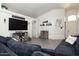 Inviting living room with TV, decorative shelves, cabinets and comfortable dark blue sofa with pillows at 4529 E Thistle Landing Dr, Phoenix, AZ 85044