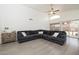 Bright living room with high ceilings, fan, gray L-shaped sofa, and sliding glass doors to the backyard at 4529 E Thistle Landing Dr, Phoenix, AZ 85044