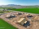 Aerial view of multiple homes under construction, set against a backdrop of farmland and mountains at 5905 S 182Nd Ave, Goodyear, AZ 85338