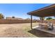 Spacious backyard with a covered patio area and ample space for outdoor activities under a clear sky at 6351 W Mountain View Rd, Glendale, AZ 85302