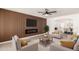 Bright living room featuring a modern fireplace, wood accent wall, and contemporary furnishings under a ceiling fan at 6351 W Mountain View Rd, Glendale, AZ 85302