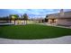Expansive backyard featuring lush green grass, a playground, a covered seating area, and a lovely home exterior at 6718 E Caron Dr, Paradise Valley, AZ 85253