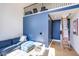 A bright living room with a blue sectional couch and overhead loft access via ladder at 6718 E Caron Dr, Paradise Valley, AZ 85253