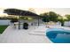 Outdoor kitchen and pergola by pool with an outdoor fire pit at 6718 E Caron Dr, Paradise Valley, AZ 85253