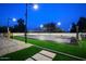 Well-lit sports court featuring basketball and volleyball, complemented by a sand volleyball court and lush turf at 6718 E Caron Dr, Paradise Valley, AZ 85253