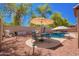 Outdoor dining area with a shaded patio and a well-maintained gravel backyard at 9259 W Caron Cir, Peoria, AZ 85345