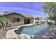 Lush backyard featuring a swimming pool, waterfall, and patio area for outdoor enjoyment at 9259 W Caron Cir, Peoria, AZ 85345