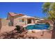 Backyard shows an inviting pool with waterfall, complemented by stylish seating and meticulously arranged gravel at 9259 W Caron Cir, Peoria, AZ 85345