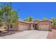 Charming home featuring a three car garage, desert landscaping, and a red tiled roof at 9259 W Caron Cir, Peoria, AZ 85345