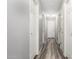 A hallway with gray walls, vinyl floors, and multiple white doors with gold doorknobs at 9259 W Caron Cir, Peoria, AZ 85345
