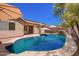 Inviting backyard pool with a rock waterfall feature and patio seating, perfect for outdoor entertaining at 9259 W Caron Cir, Peoria, AZ 85345