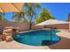 Refreshing pool featuring a rock waterfall and shaded seating area, ideal for relaxation at 9259 W Caron Cir, Peoria, AZ 85345