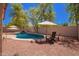 Backyard boasts a dazzling pool with waterfall feature, charming lounge seating, and meticulously laid gravel at 9259 W Caron Cir, Peoria, AZ 85345