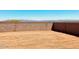 Large undeveloped backyard with a block wall, offering a blank canvas for landscaping and customization at 11912 E Aster Ln, Florence, AZ 85132