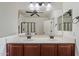 Bathroom featuring double sinks, a large mirror, and a shower with sleek glass doors at 12217 W Planada Ln, Sun City, AZ 85373