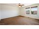 Bedroom with two windows offering natural light and brown carpet flooring at 12217 W Planada Ln, Sun City, AZ 85373