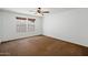 Empty bedroom with two windows, ceiling fan and neutral brown carpeting at 12217 W Planada Ln, Sun City, AZ 85373
