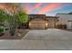 Charming home with a three-car garage, manicured landscaping, and a beautiful sunset backdrop at 12217 W Planada Ln, Sun City, AZ 85373