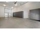 Spacious garage with epoxy flooring, overhead lighting, and custom gray cabinetry at 12217 W Planada Ln, Sun City, AZ 85373