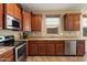 Well-appointed kitchen with stainless steel appliances, wooden cabinetry, and tile flooring at 12217 W Planada Ln, Sun City, AZ 85373