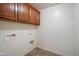 This laundry room has overhead cabinets and tile flooring at 12217 W Planada Ln, Sun City, AZ 85373