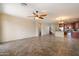 Open-concept living area showcases tile floors, ceiling fan, and flows into the kitchen and staircase at 12217 W Planada Ln, Sun City, AZ 85373