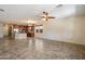 Open-concept living space with tile floors seamlessly connecting to a kitchen featuring a breakfast bar and stainless appliances at 12217 W Planada Ln, Sun City, AZ 85373